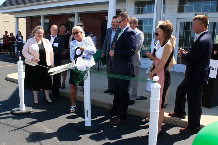 Karen Taylor, chair of the board for InfoCision, performs a ribbon cutting in front of the company’s newest call center on Reynolds Road in Toledo