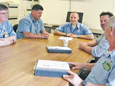Tom Ostrosky (second from right) speaks with a group of prisoners