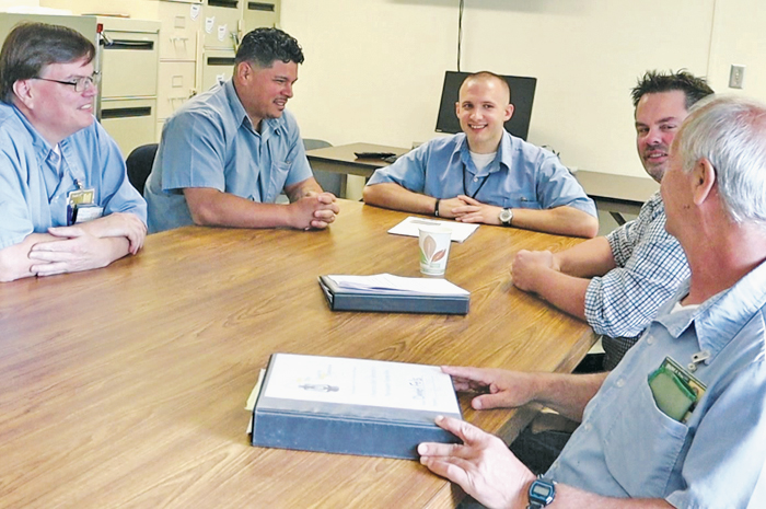 Tom Ostrosky (second from right) speaks with a group of prisoners
